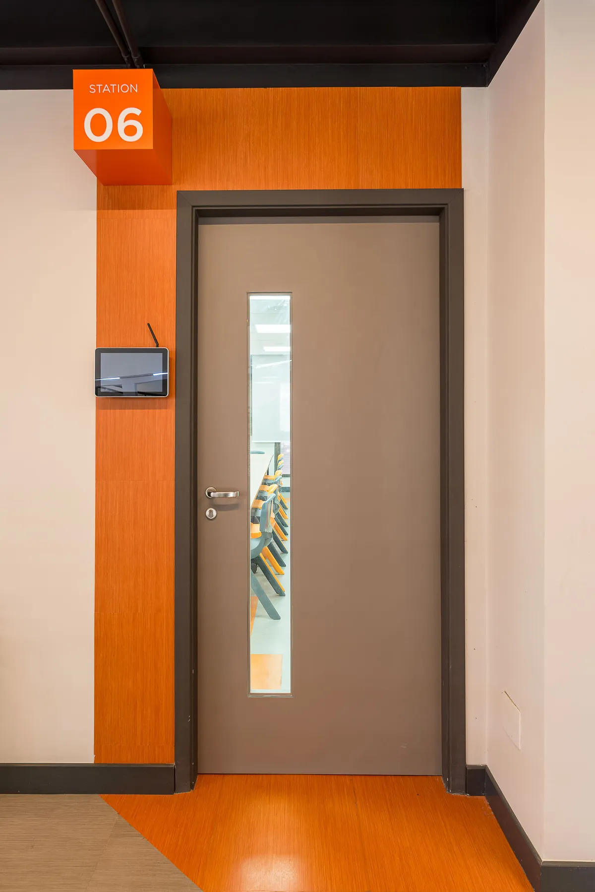 Porta de sala de aula com batente laranja e placa com o número 06.